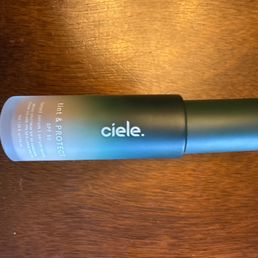 The winner - A cylindrical bottle of Cielé tinted moisturizer with SPF 50 is placed on a wooden surface, showing the product label and branding.