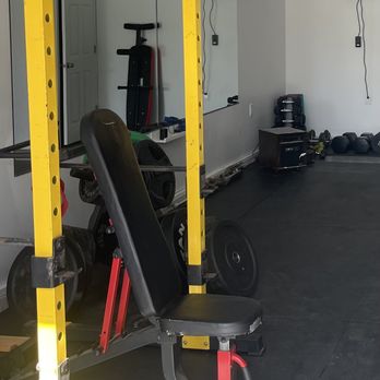 M-Build - a gym room with a bench and weights - General Contractors Near Me M-Build - a gym room with a bench and weights - General Contractors Near Me