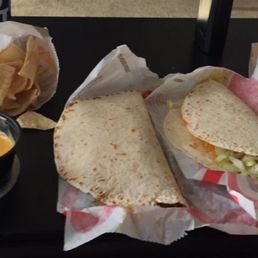 Two soft tacos with chips and cheese