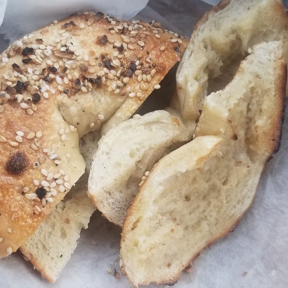 Bagel Smith - a half eaten bagel with a bite taken out of it - Bagels Near Me - Smithtown, New York