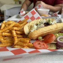 Chris Specialty Foods - Ribeye po-boy with onions, bell peppers, and melted provolone cheese.