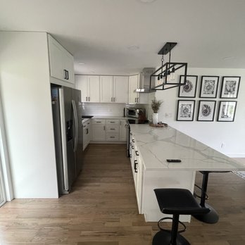 Stonewood Design - a kitchen with white cabinets and wood floors - Flooring Near Me - Kirkland, Washington
