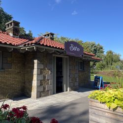 Bistro - Storefront. The sign above says "Bistro" (though it is operated by Moulin in the Park). In the background, steps lead to QE Driveway.