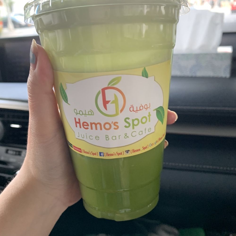 a hand holding a green drink a hand holding a green drink