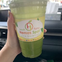 a hand holding a green drink