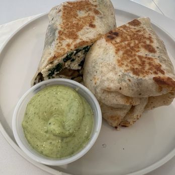 Lyfe Cafe - Sunrise Wrap (Eggwhite wrap) - Egg white wraps filled with ingredients, served with a green sauce on a white plate at Lyfe Cafe in Westport, CT. - Breakfast & Brunch Near Me - Westport, Connecticut
