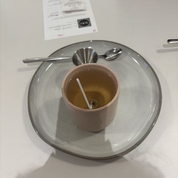 AURA Candle Bar - My candle - A candle-making station features a pink candle, metal spoon and scoop, and a receipt on a white table, indicating a craft activity. - Candle Stores Near Me - Chicago, Illinois