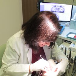Echeverri Dental Center - Dr. Elsa applying sealants to a pediatric patient