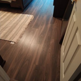 Rustic Floors - a bedroom with a bed and dresser - Flooring Near Me