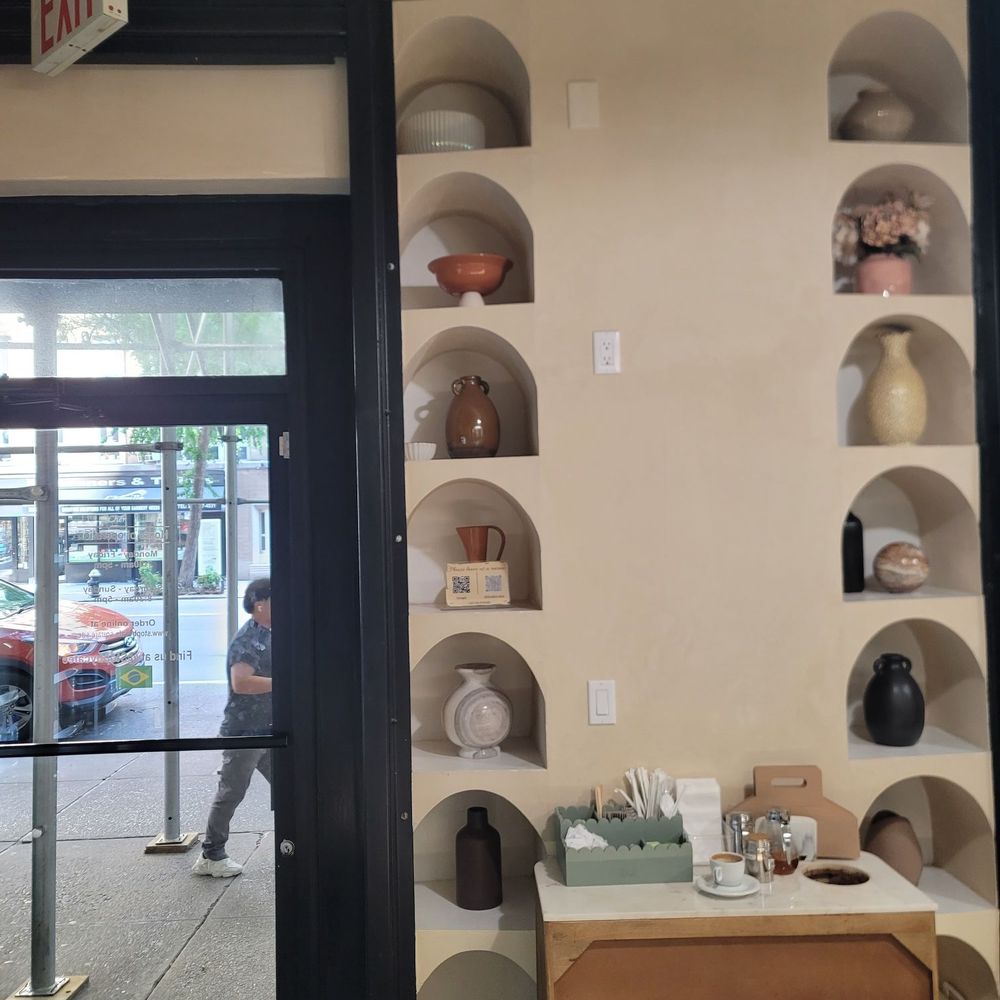 Stop By Café - Facing the entrance and design of assorted pottery on the wall - Bakeries Near Me - New York, New York Stop By Café - Facing the entrance and design of assorted pottery on the wall - Bakeries Near Me - New York, New York