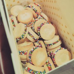 Caity's Homemade Treats & Sweets - Gift cookie tote with 30 mini custom alfajores featuring swirled milk and white chocolate filling, edged in rainbow nonpareils.