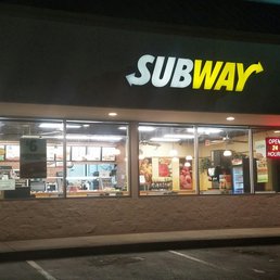 the entrance of a subway restaurant at night