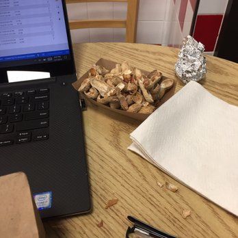 Five Guys - a table with a laptop and a bowl of wood chips - Burgers Near Me - Boulder, Colorado