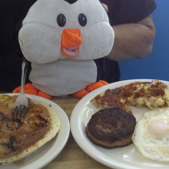 Penguin Cafe - The Griddle Combo with Banana Pancakes, Eggs over easy, Sausage, and Potatoes - Breakfast & Brunch Near Me - Laguna Beach, California