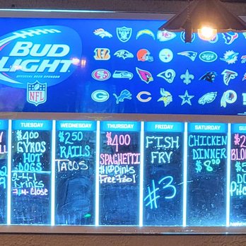 EJ's - Weekly specials - A brightly lit neon menu board displays weekly specials for a bar or restaurant, including food and drink deals for each day of the week, with NFL team logos above. - Dive Bars Near Me - Hubertus, Wisconsin