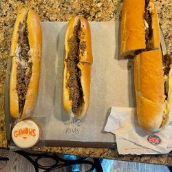 G-Knows Cheesesteaks - Three cheesesteaks L-R.  G-Knows $17.44 per pound. Little Mias $8.02 per pound. Jersey Mikes $12.27 per pound.