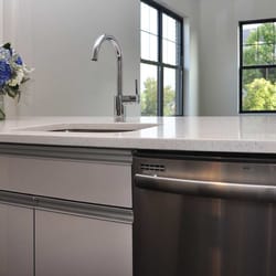24 N Main Apartments - Kitchens have quartz counter tops, stainless steel appliances, and grey lacquer  cabinets.