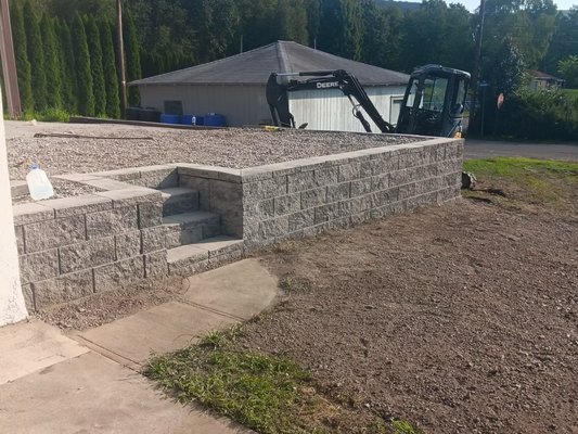 Retaining Wall - The backyard was upgraded with a new retaining wall with steps and a sidewalk, bringing a charming yet functional appearance. We leveled the ground, then constructed the wall with layering blocks. Retaining Wall - The backyard was upgraded with a new retaining wall with steps and a sidewalk, bringing a charming yet functional appearance. We leveled the ground, then constructed the wall with layering blocks.