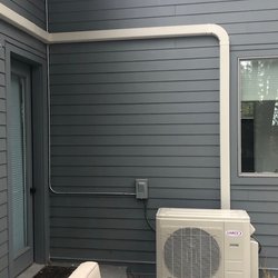 Central Heating & Cooling - Exterior HVAC mini-split unit. Note the quality installation - when painted, the conduits will disappear.