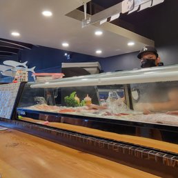 a man behind a sushi bar
