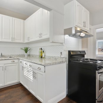 Rose Construction Services - a kitchen with white cabinets and black appliances - General Contractors Near Me Rose Construction Services - a kitchen with white cabinets and black appliances - General Contractors Near Me