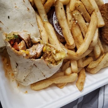 Rudi's - Soggy southwest wrap and ketchup hidden in soggy old fried to make it look like more.  Southwest Wrap  French Fries - A food tray contains French fries, a partially eaten wrap with vegetables and meat, and a fried item, all on a striped fabric surface. - Sports Bars Near Me - Patchogue, New York