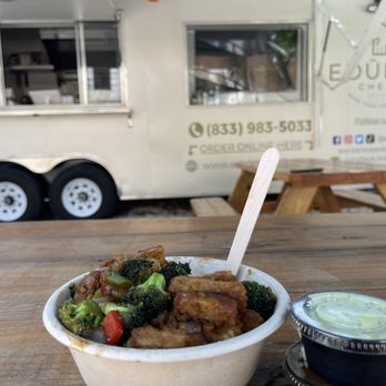Eduble Chefs - a bowl of broccoli and meat in front of a food truck - Vegan Near Me - Miami, Florida Eduble Chefs - a bowl of broccoli and meat in front of a food truck - Vegan Near Me - Miami, Florida