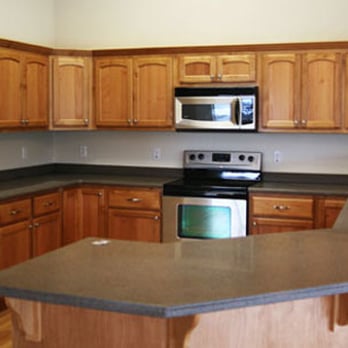 Bridges Construction - a kitchen with wood cabinets and stainless steel appliances - General Contractors Near Me - Lakeport, California