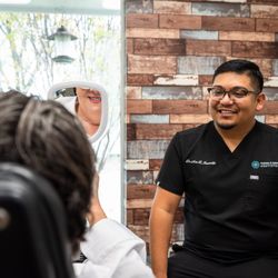 Aesthetic & Implant Dentistry - Dr. Jaramillo showing a patient their smile at Aesthetic & Implant Dentistry