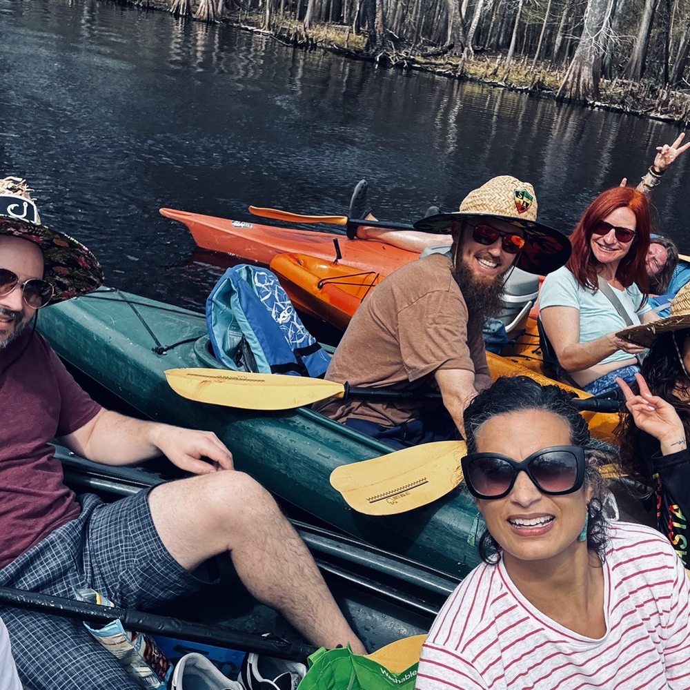 Friends connecting kayaks on the Santa Fe River, celebrating a birthday.