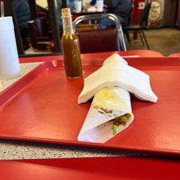 a burrito on a red tray at a restaurant a burrito on a red tray at a restaurant