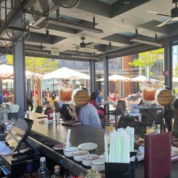 To the northwest, umbrellaed tables beyond the shaded open bar, with a creative skilled acoustic duo off to the right To the northwest, umbrellaed tables beyond the shaded open bar, with a creative skilled acoustic duo off to the right