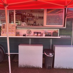 a green food truck with a red canopy
