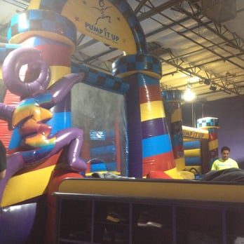 Pump It Up Oakland - Inflatable jump house and view of the big rolling cubbie cart with kids shoes that follows the party to the next room. - Indoor Playcenter Near Me - Oakland, California