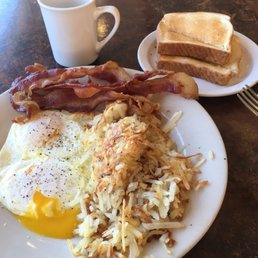 Over easy eggs, bacon, hash browns, toast and coffee. Over easy eggs, bacon, hash browns, toast and coffee.