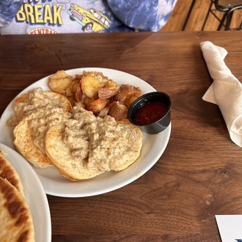 Rusk Kitchen & Bar - Pork sausage gravy and biscuits with potatoes - Cocktail Bars Near Me - Cincinnati, Ohio