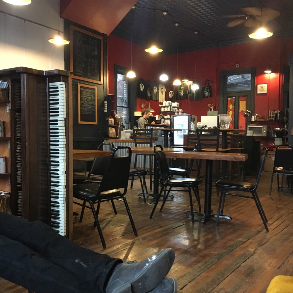 a man laying on a bench in a coffee shop