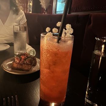 Do Not Disturb - a woman sitting at a table in a restaurant - Speakeasies Near Me - New York, New York