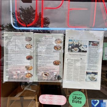 Cafe Paprika - Menu and magazine article about restaurant are present on window - Moroccan Near Me - Aurora, Colorado