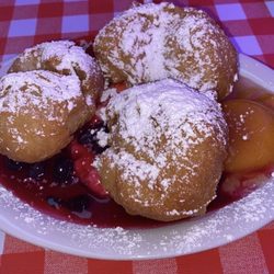 Huckleberry's Breakfast and Lunch - So much bigger than the picture on the menu . These are the Beignets with fruit topping