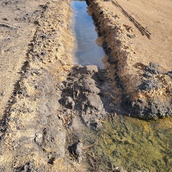 GnZ Contractor Solutions - a drainage ditch in a field - Roofing Near Me - Cabot, Arkansas