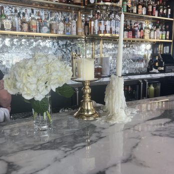 Sorella - Having a cocktail at the bar before dinner. Love the fresh flowers and real candles. - Italian Near Me - Spokane, Washington