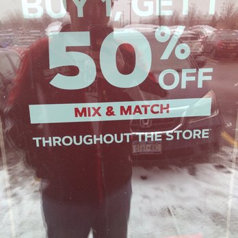 GNC - a man standing in front of a store window - Health Markets Near Me - Amherst, New York
