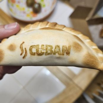 Buddies Bakery - a hand holding a piece of bread with the word cuban written on it - Coffee & Tea Near Me - Cooper City, Florida Buddies Bakery - a hand holding a piece of bread with the word cuban written on it - Coffee & Tea Near Me - Cooper City, Florida
