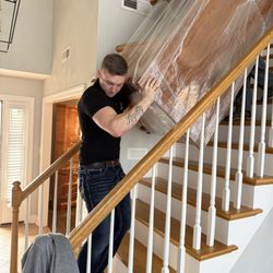 Big Dawgs Moving & Hauling - Professionals handling & Maneuvering a huge office desk down steep stairs.