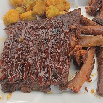Smokin' Hogan's - Barbecue ribs with sauce, fried okra, and baked sweet potato fries served on a white plate, typical of a country-style eatery. - Barbeque Near Me - Corydon, Indiana