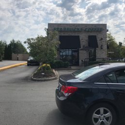 a black car parked in front of a coffee shop a black car parked in front of a coffee shop