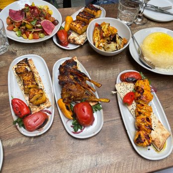 Delbar Middle Eastern - A feast! Sea bass, lamb chops, chicken, rice, grilled veggies, salmon, heirloom tomato salad, - Persian/Iranian Near Me - Atlanta, Georgia