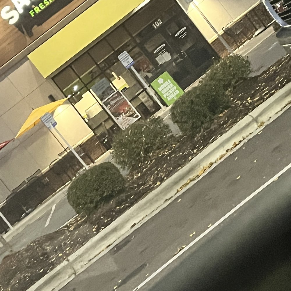 a green car parked in front of a restaurant a green car parked in front of a restaurant