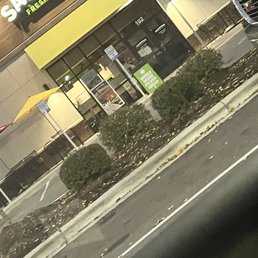a green car parked in front of a restaurant